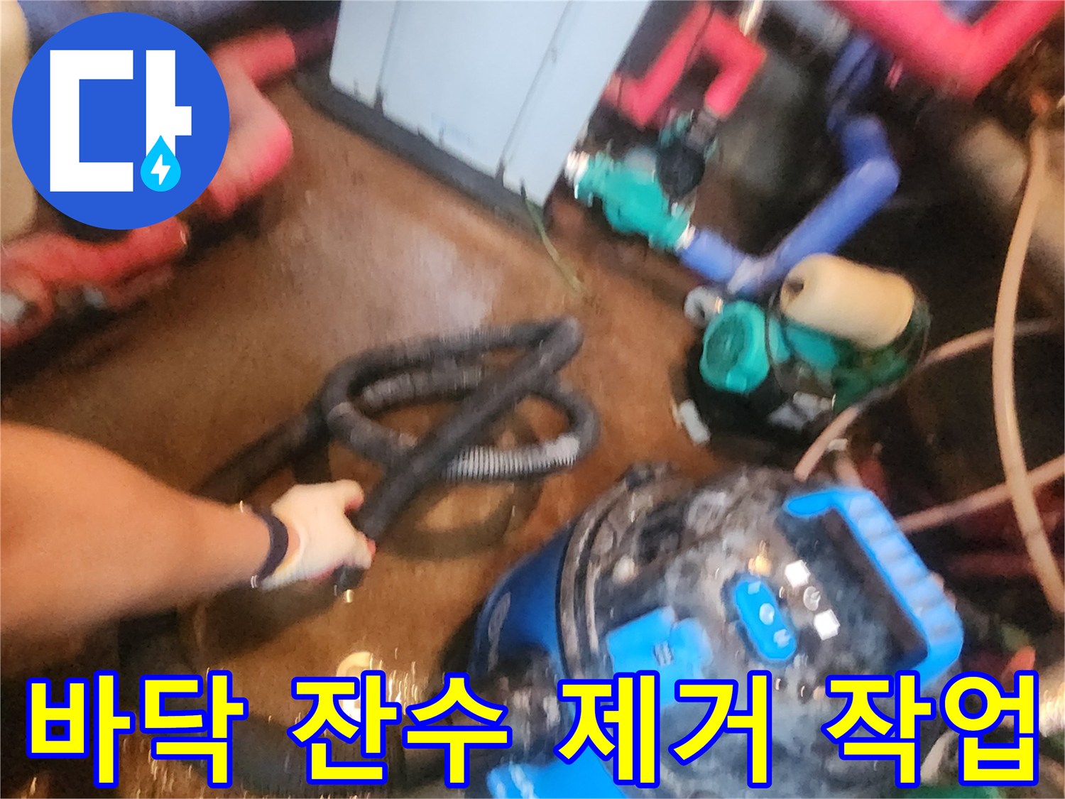 파란색 셕션 장비로 바닥의 물을 빨아들이는 중