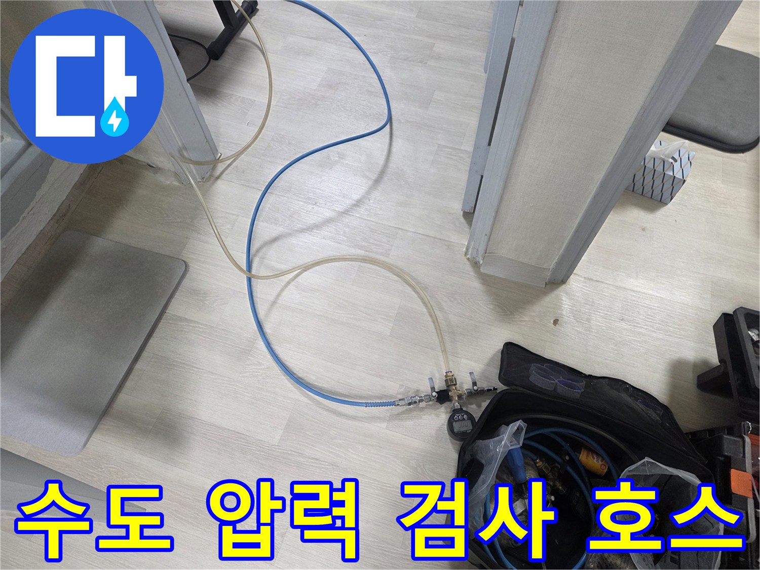 바닥을 가로질러 연결된 파란색 공압용 호스