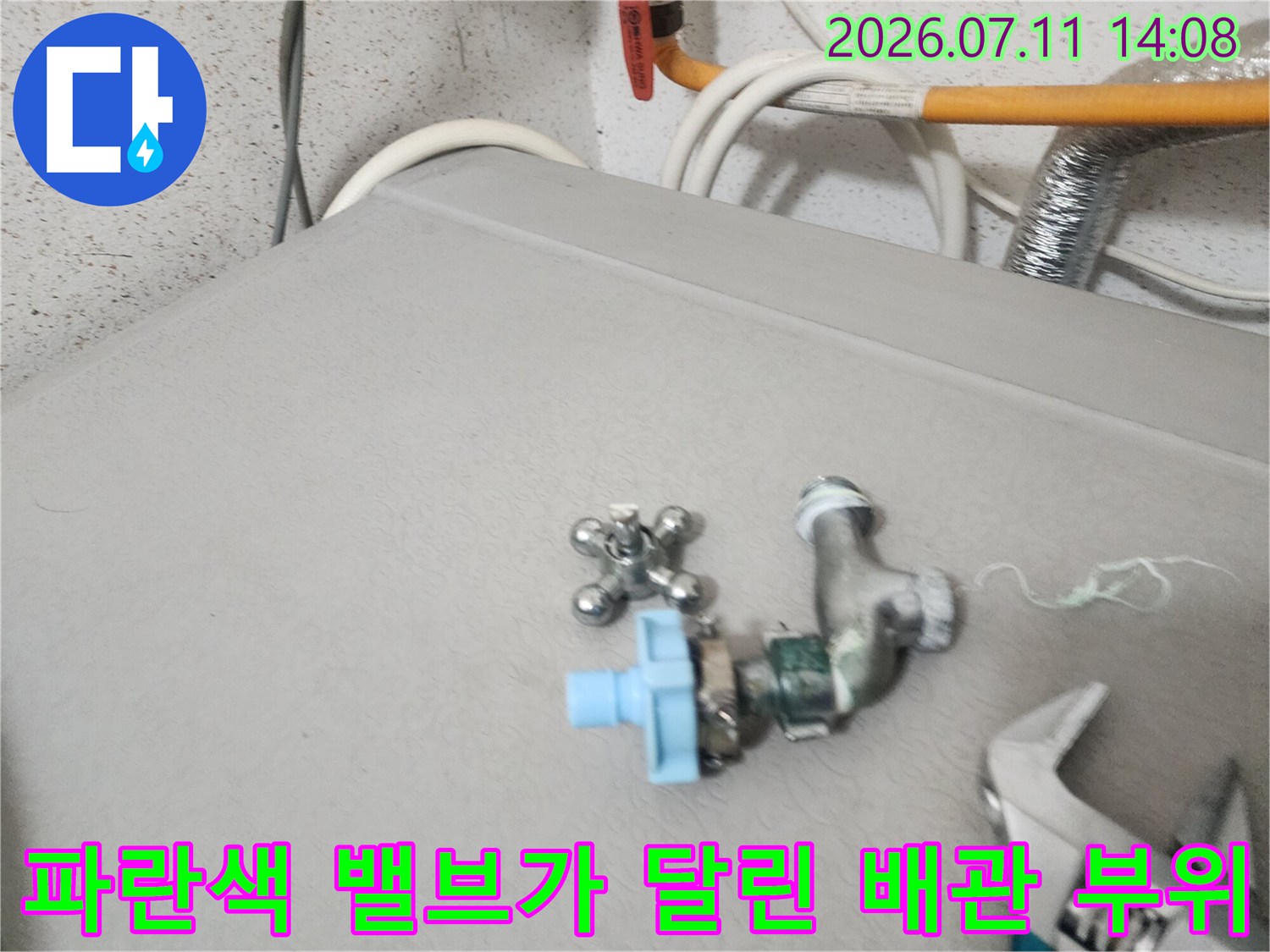 파란색 수동 밸브와 금속 파이프 연결부 확인