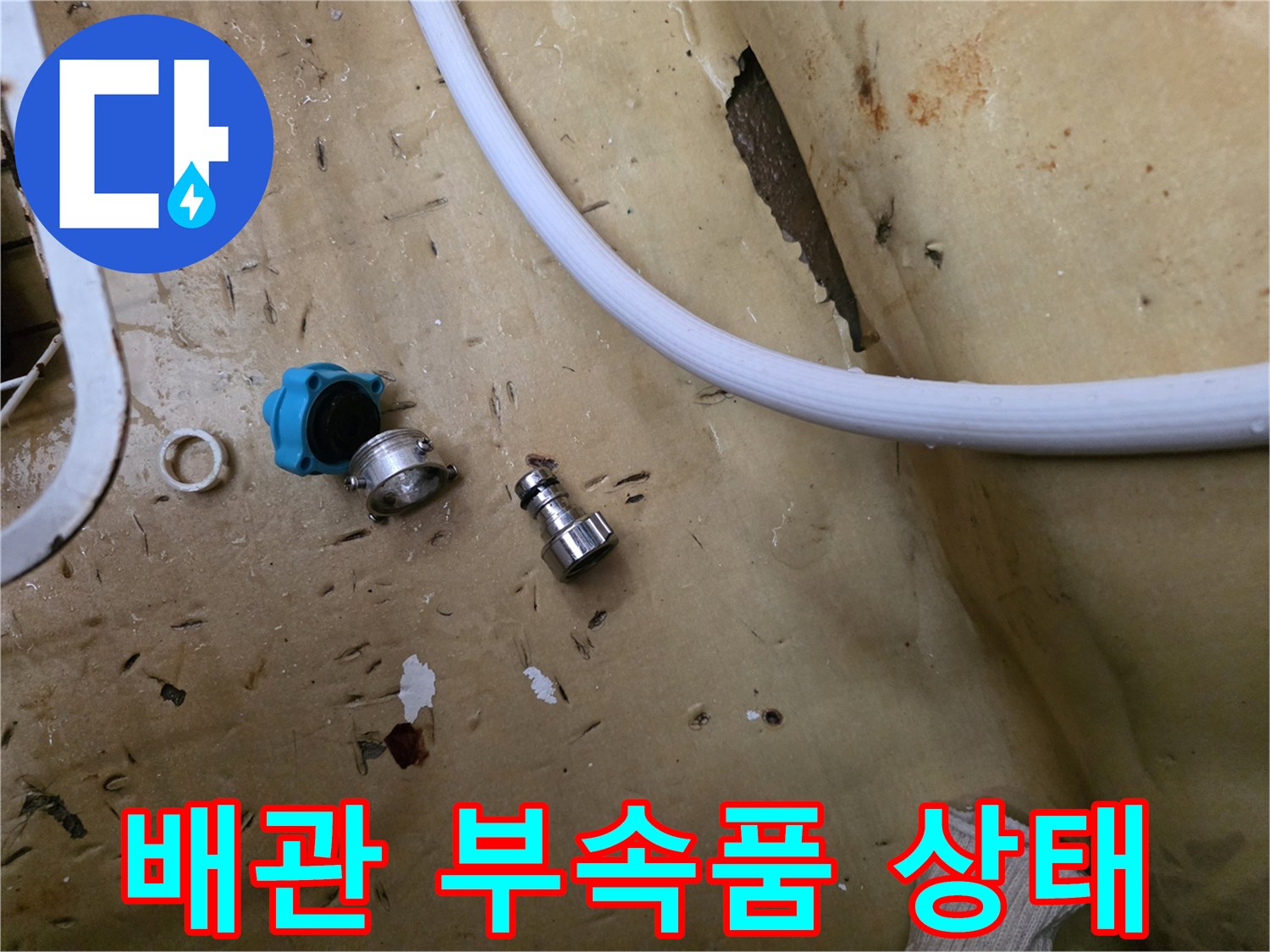 바닥에 놓인 파란색 밸브와 금속 연결 부품