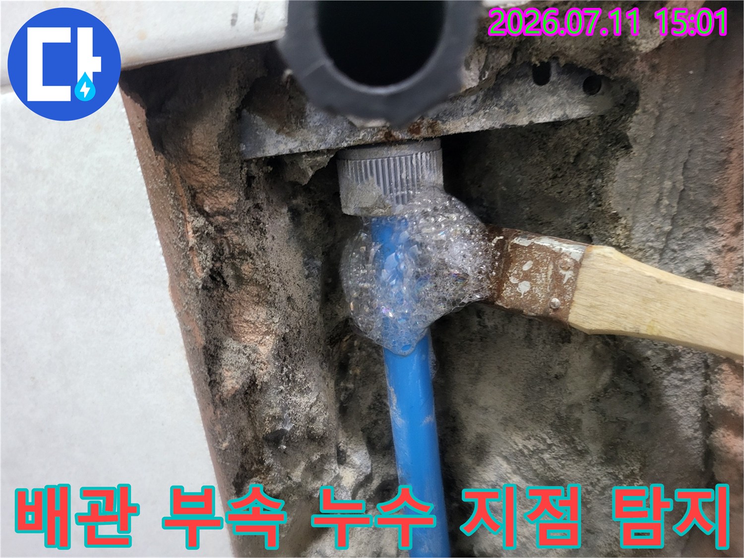 비눗방울이 맺힌 배관 연결부와 파란색 수도관의 모습