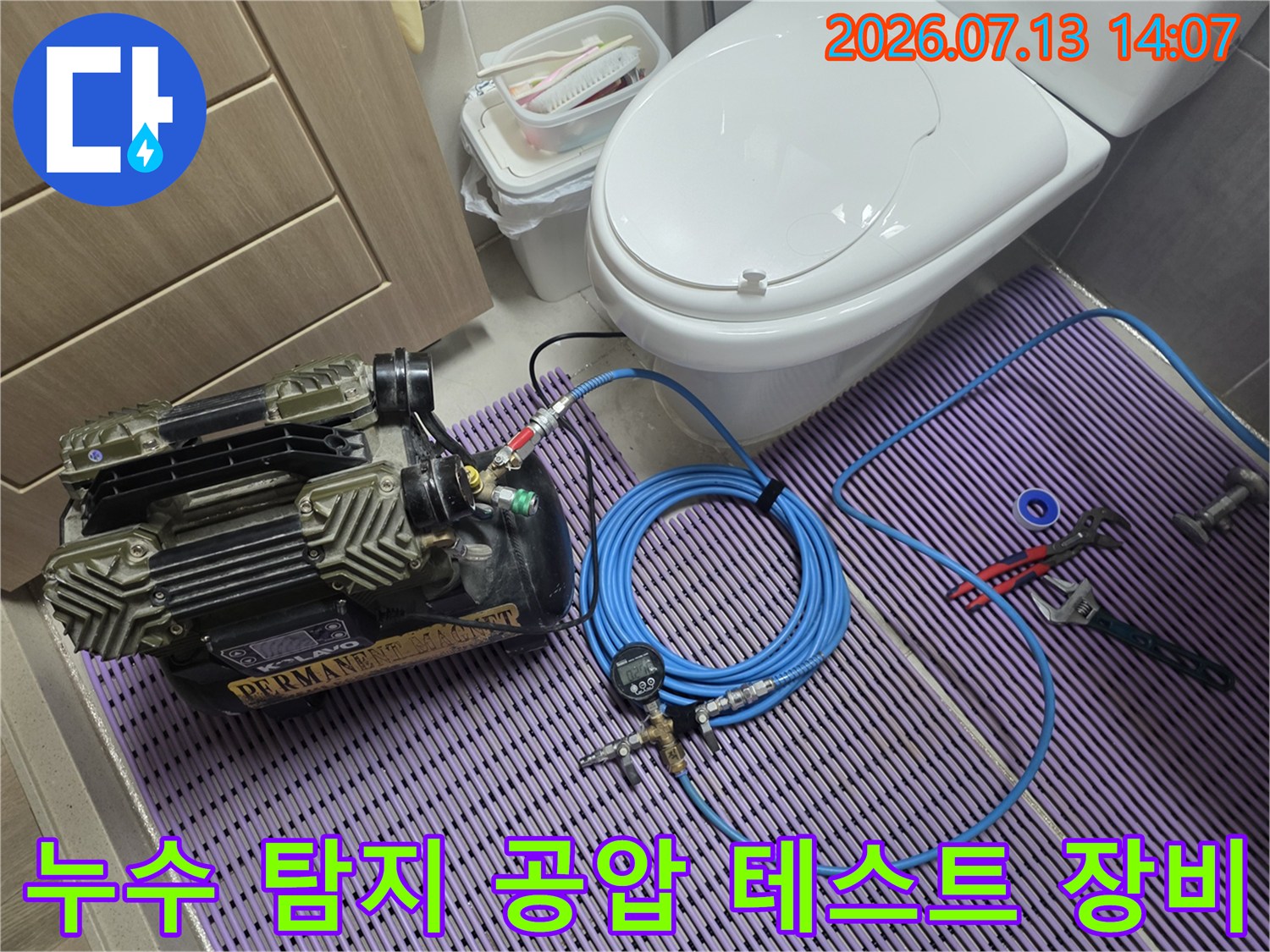 파란색 호스가 연결된 화장실용 배관 압력 측정기