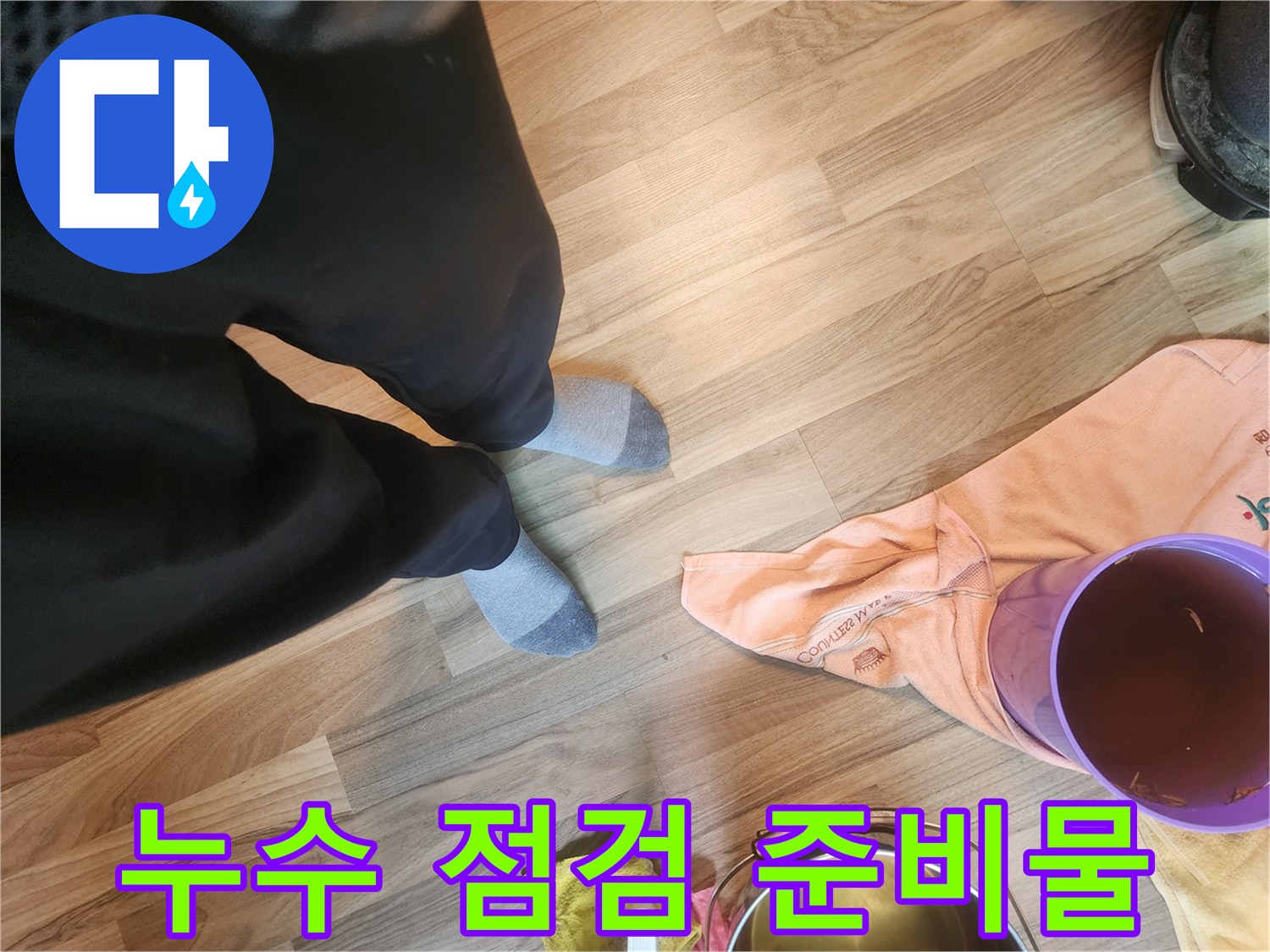바닥에 놓여 있는 보라색 용기와 수건