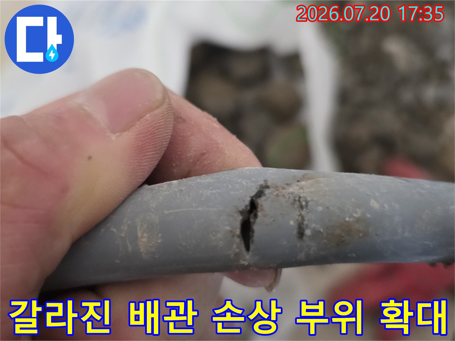 파손된 구간을 절단하여 노출한 회색 배관의 상태