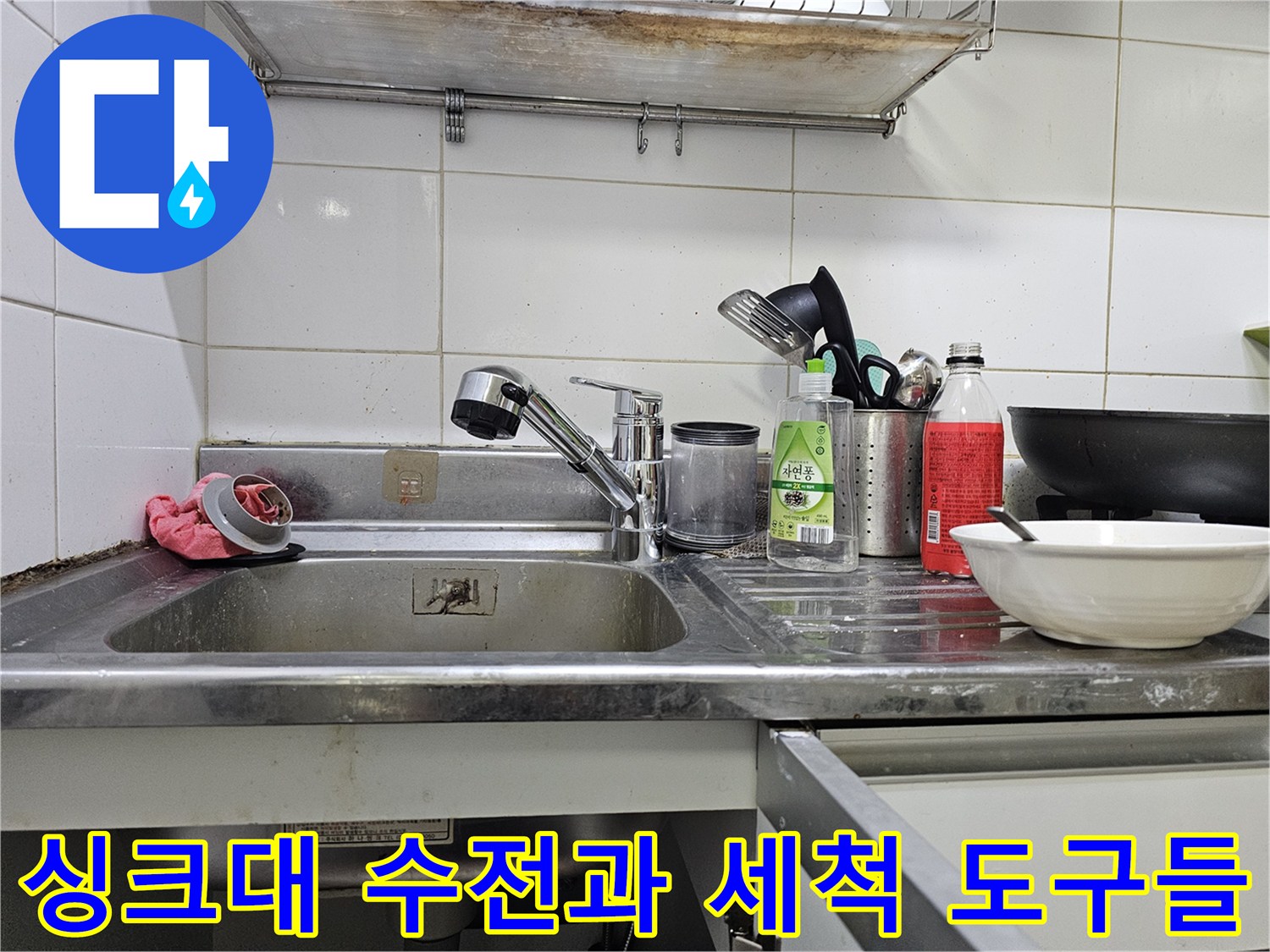 싱크대 볼 위에 놓인 수전 및 청소용품 이미지