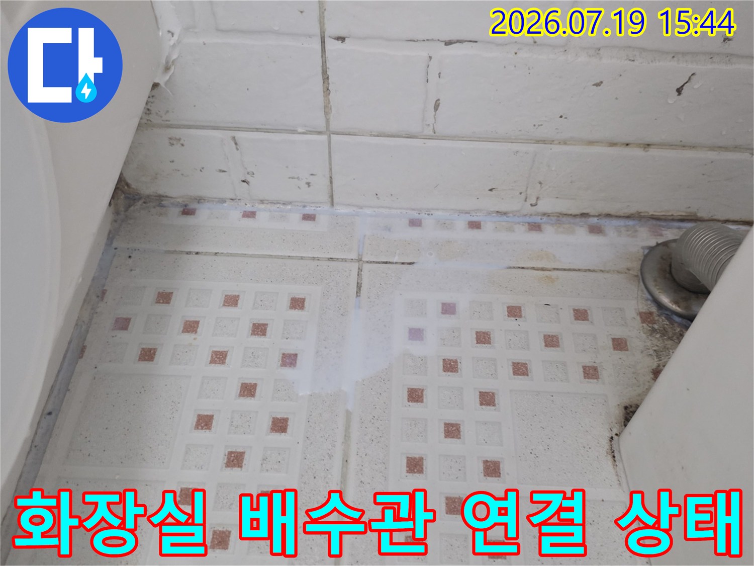 흰색-타일-위의-회색-배수구-파이프-설치-모습