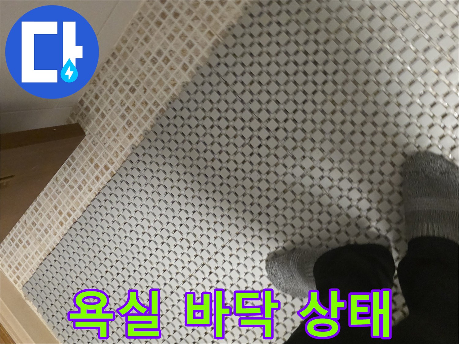 작업자가 점검 중인 화장실 바닥 타일의 모습
