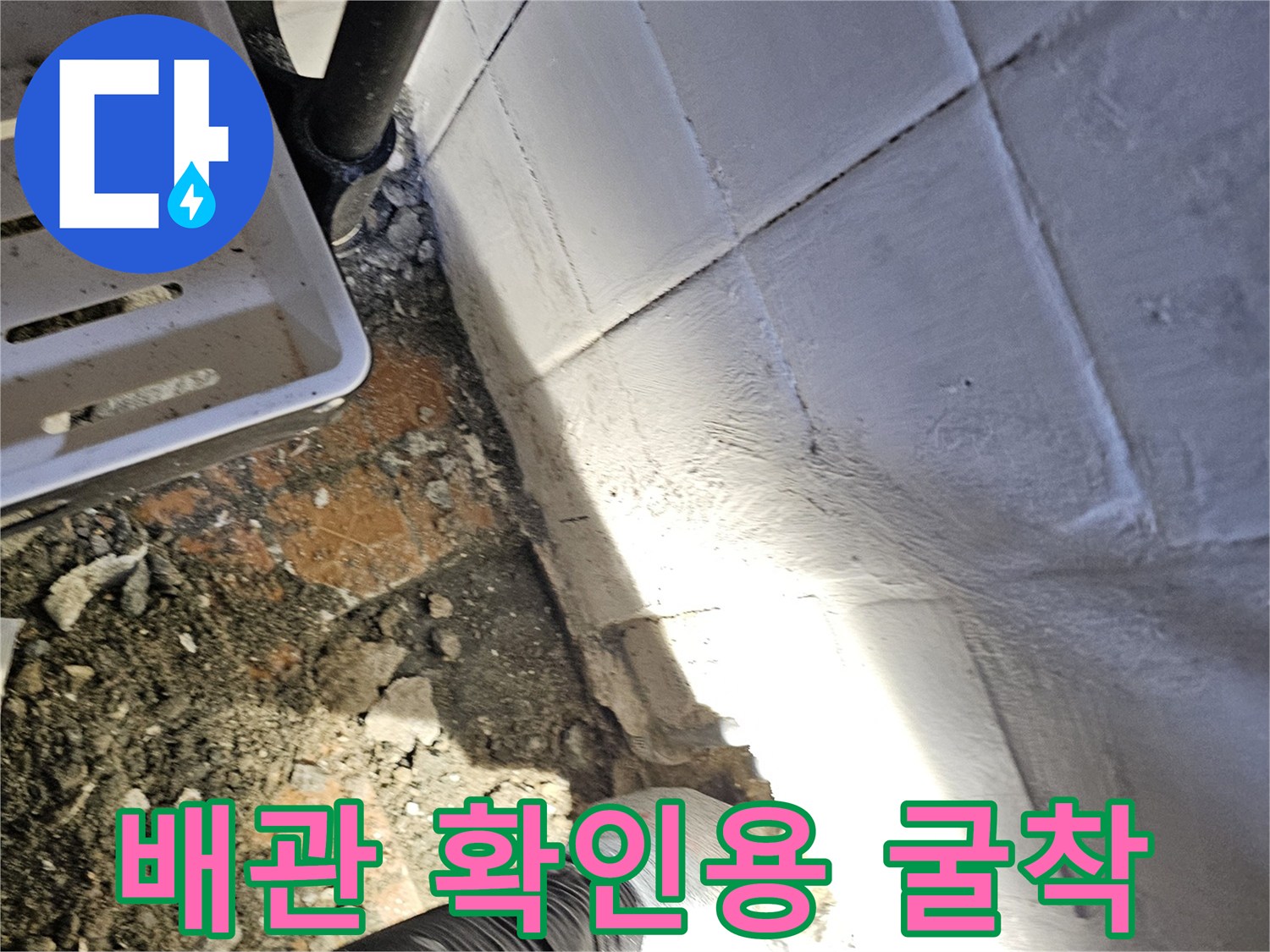 타일 벽면 아래쪽 배관을 찾기 위한 작업 현장
