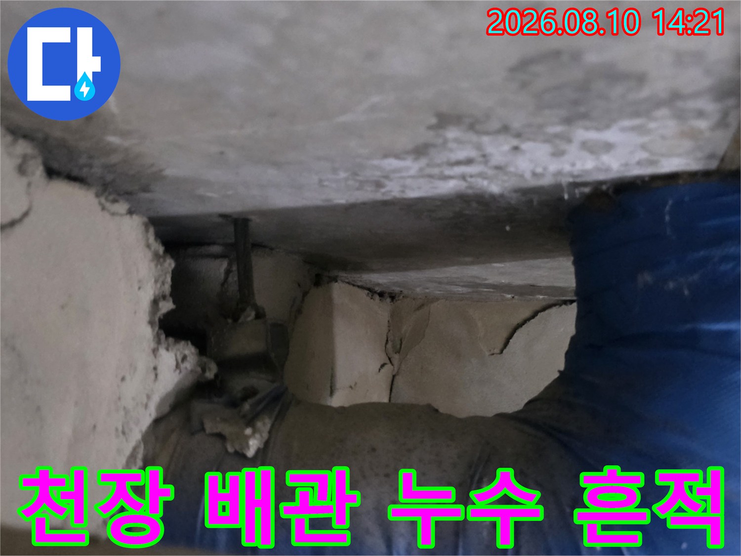 파란색 배관 주변의 젖은 마감재와 갈라진 틈새