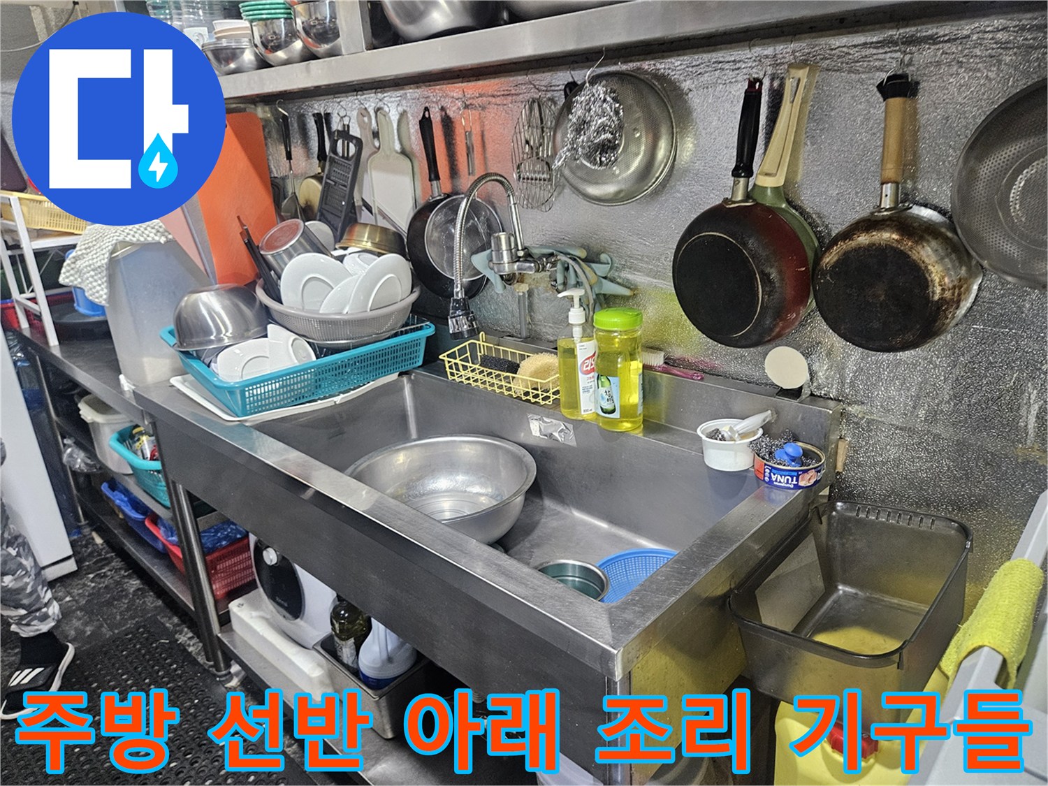 상가 주방의 냄비와 선반 하단 모습