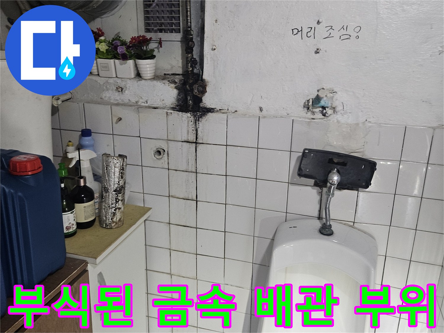 소변기 하단에 위치한 녹슨 배관 연결 부위