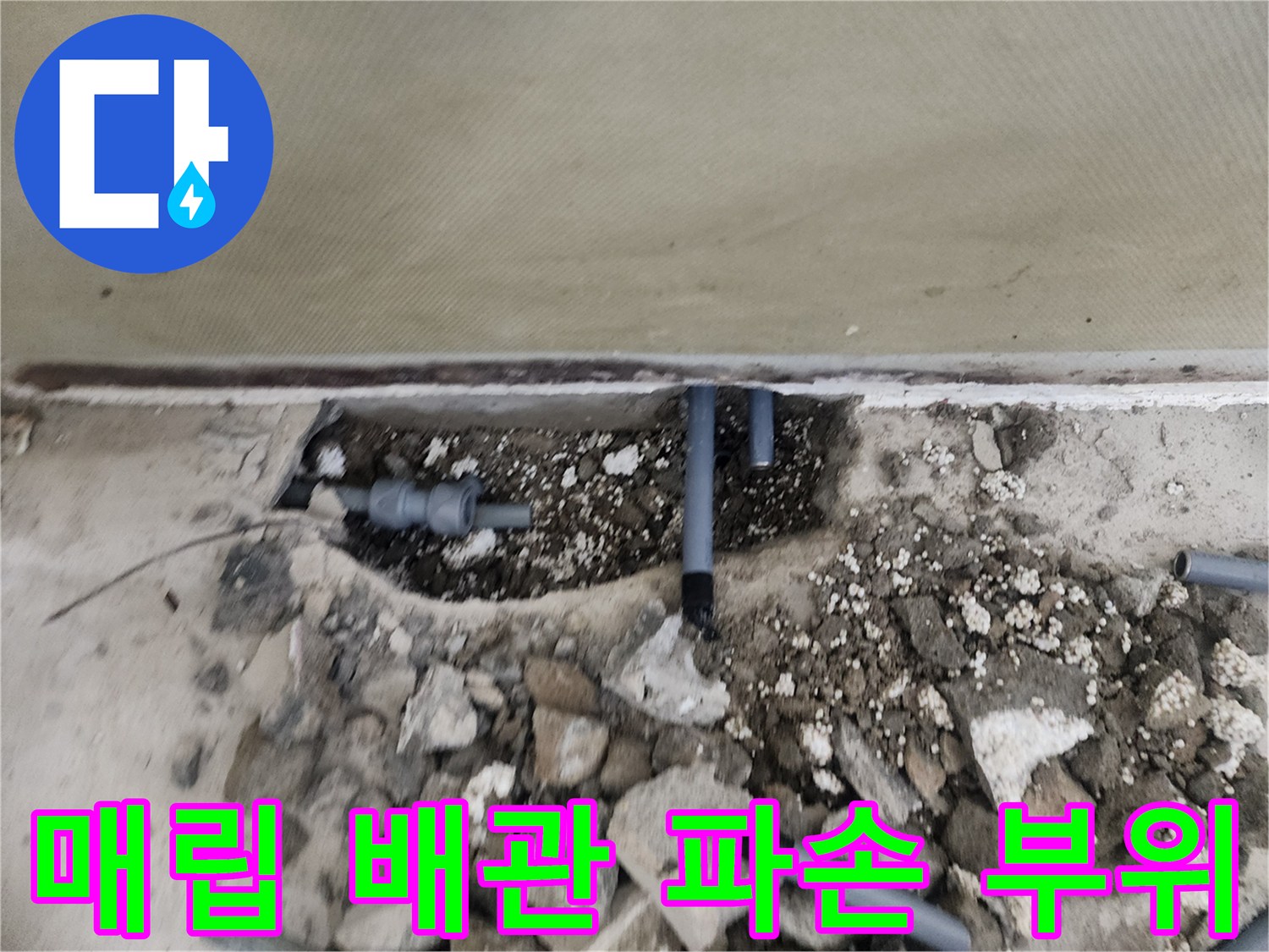 콘크리트 아래 노출된 회색 수도 배관