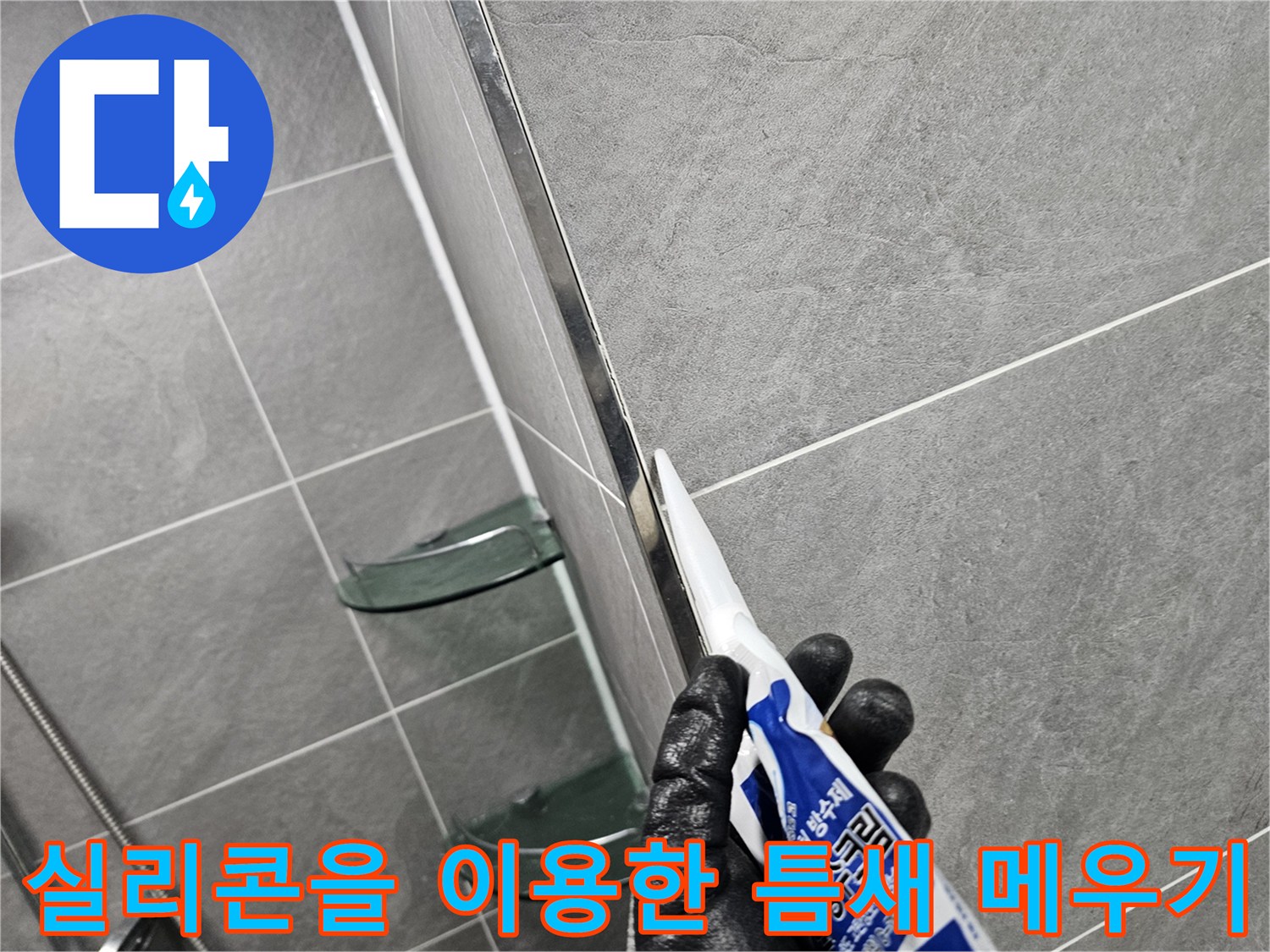 타일 사이의 벌어진 틈에 실리콘 작업 중