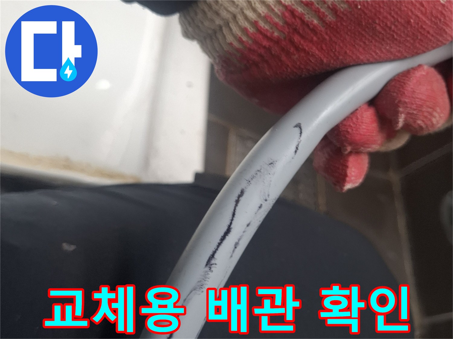 회색 배관을 쥐고 있는 작업자의 손