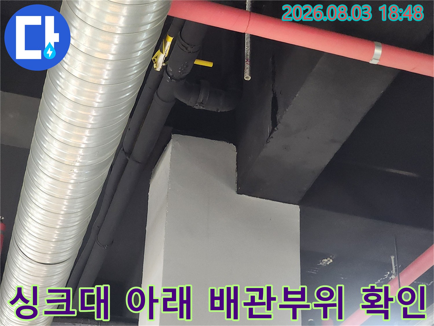 노란색 배관과 은색 주름 호스 연결 부위