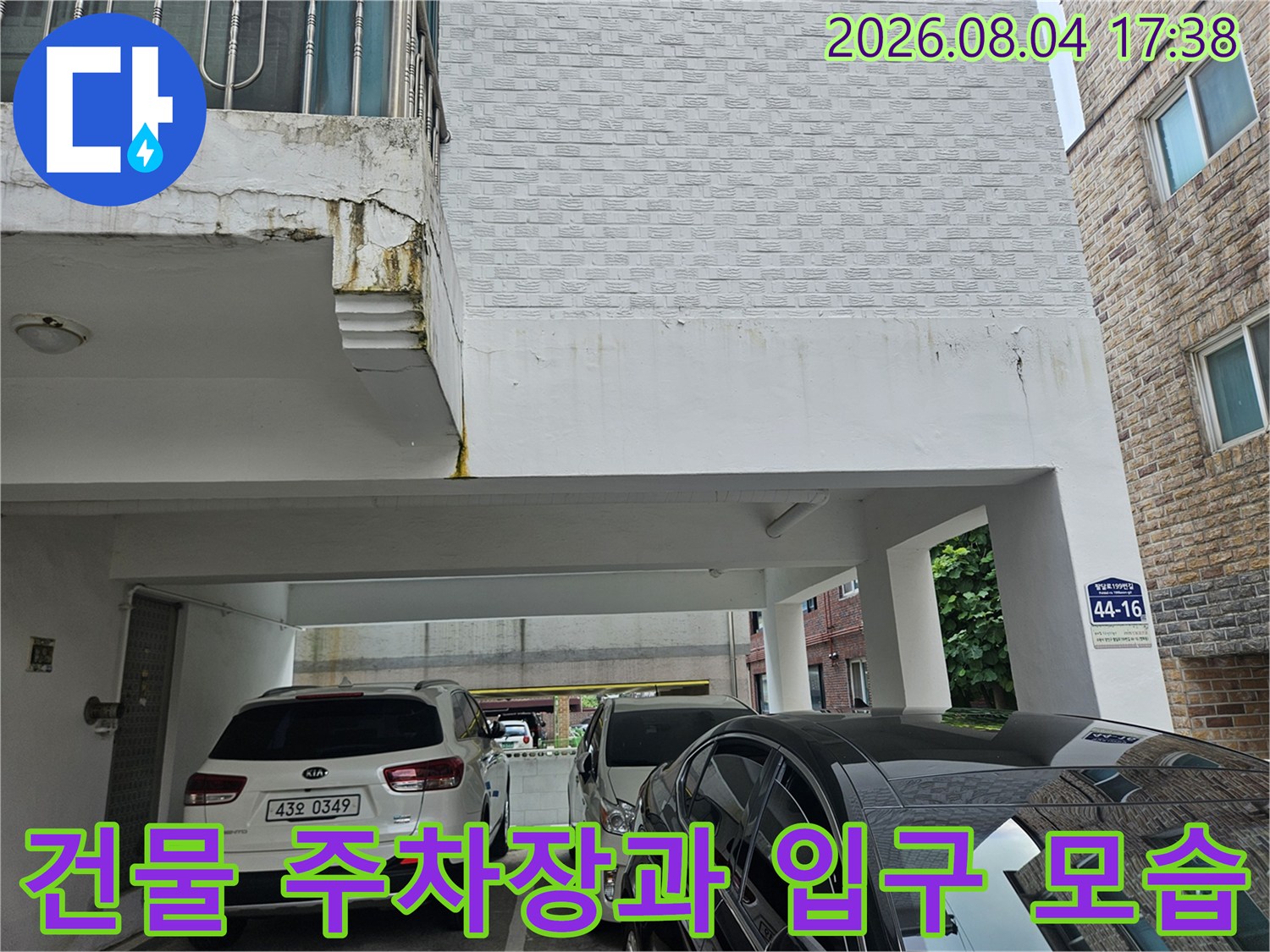 필로티 구조 건물의 외부 입구와 차량이 있는 전경