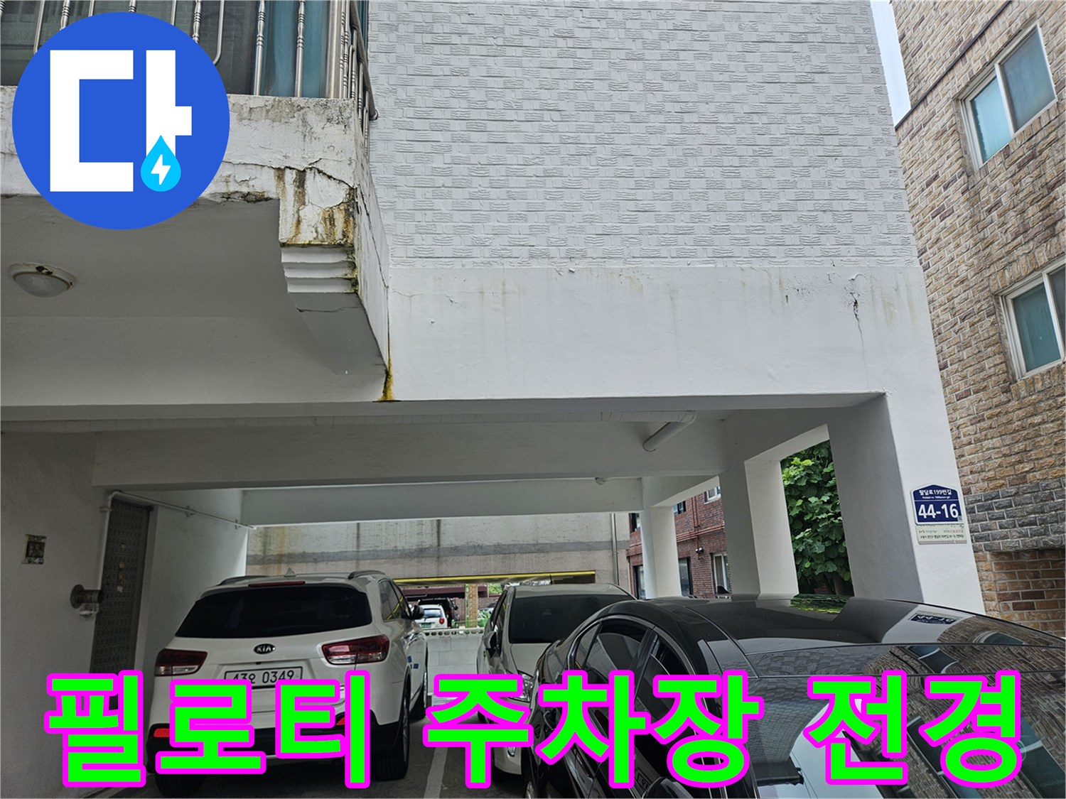 흰색 차량이 있는 필로티 구조 건물의 입구