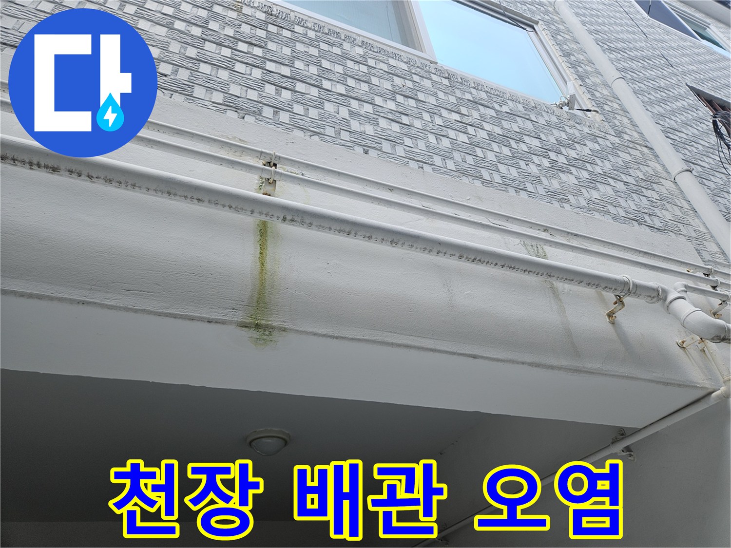 흰색 천장재와 배관 사이의 노란색 누수 흔적