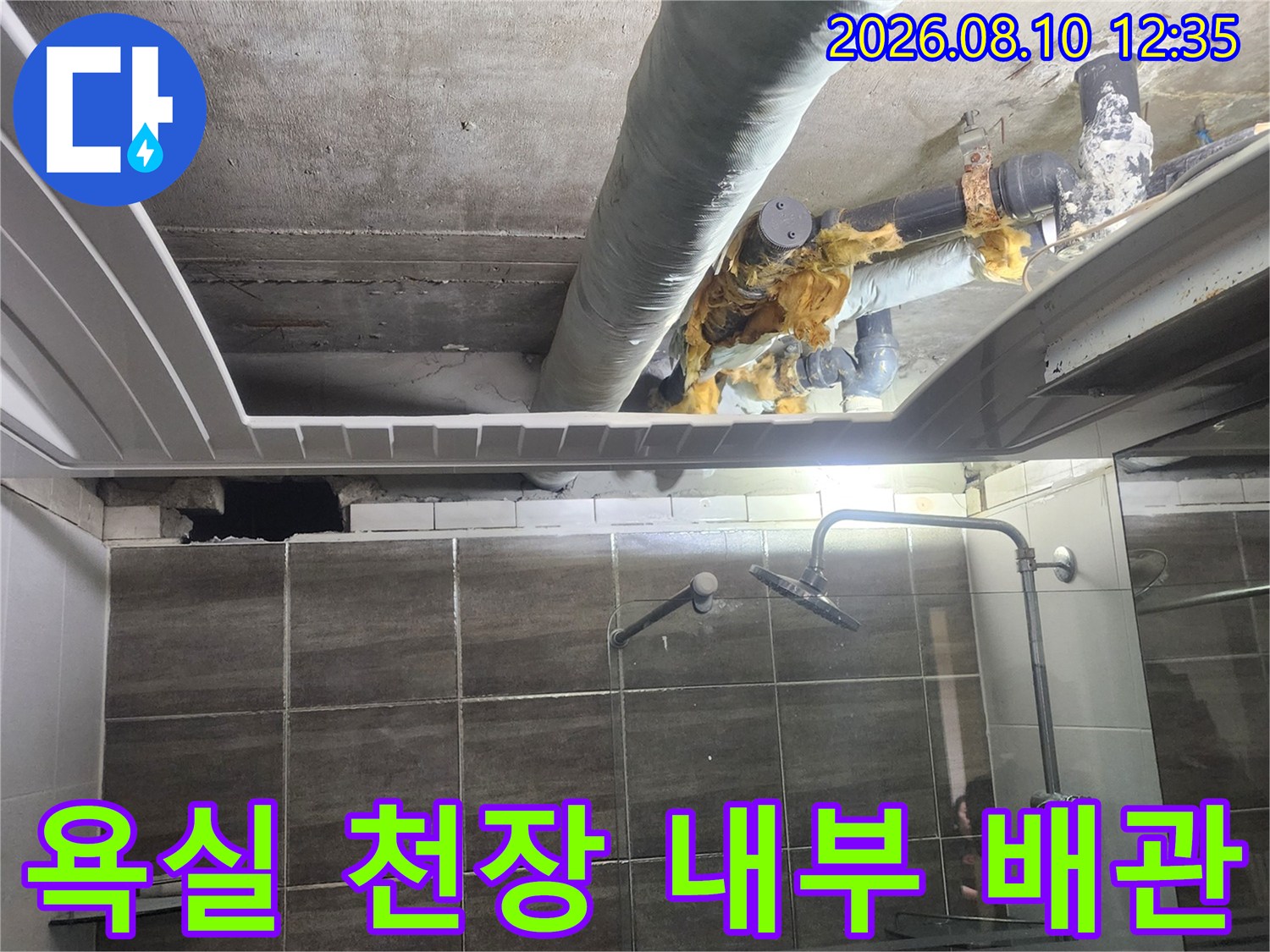 천장 마감재 안쪽의 노출된 하수 배관 구조물