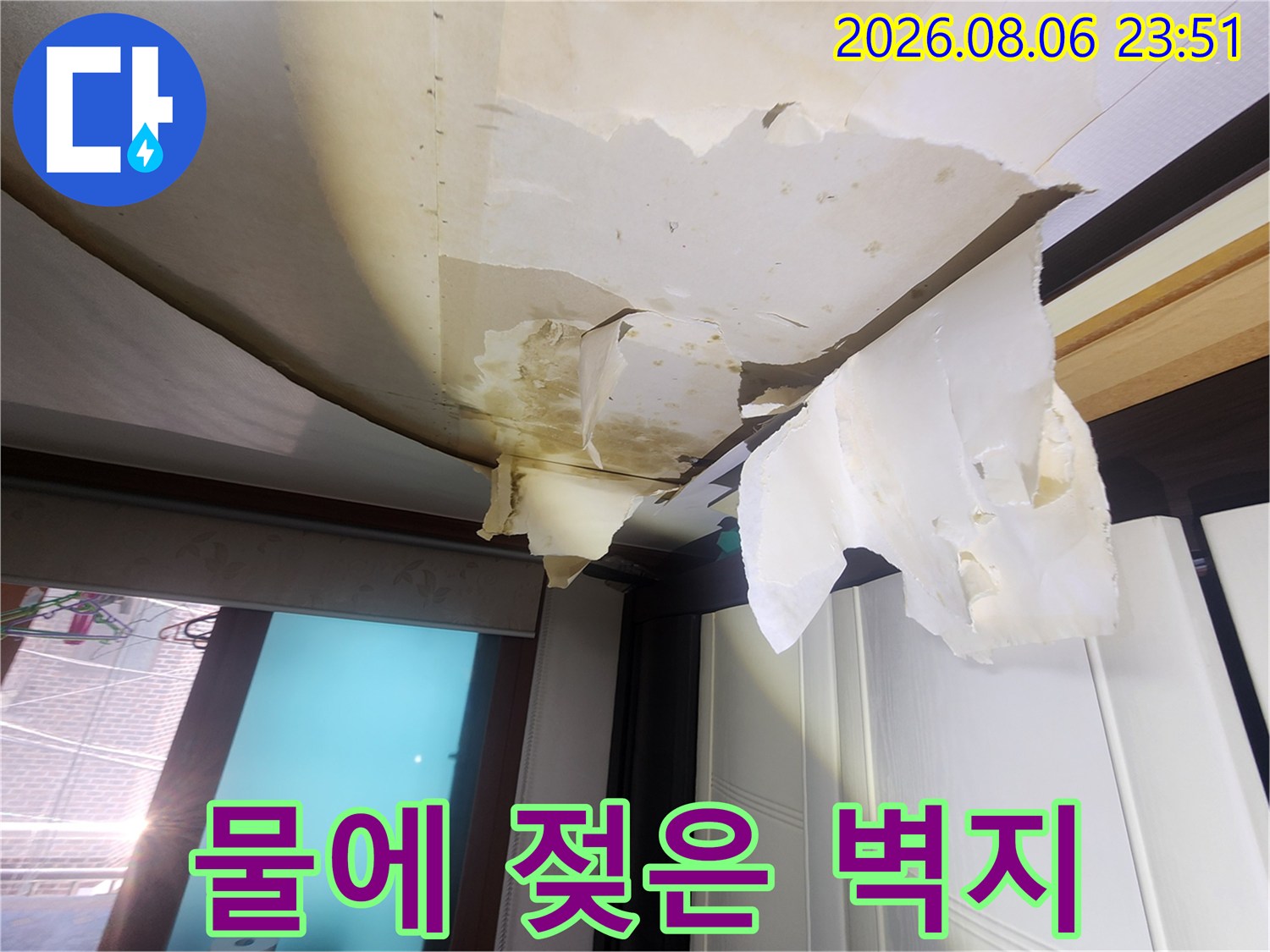 천장 도배지가 습기로 인해 들뜨고 찢어진 현장 사진입니다.