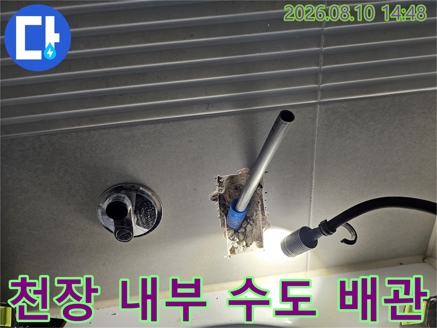 천장재를 절개하여 드러난 은색 배관과 연결 부위