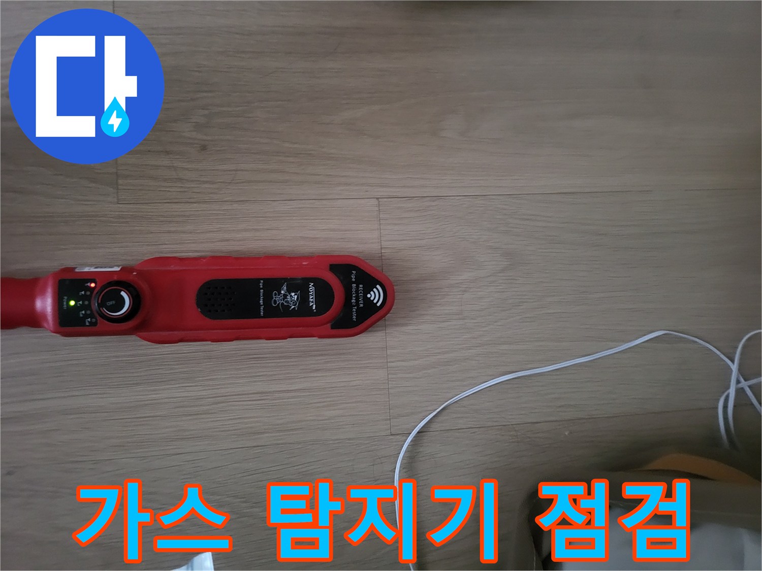 마루 바닥 위에 놓인 빨간색 가스 탐지기 장비
