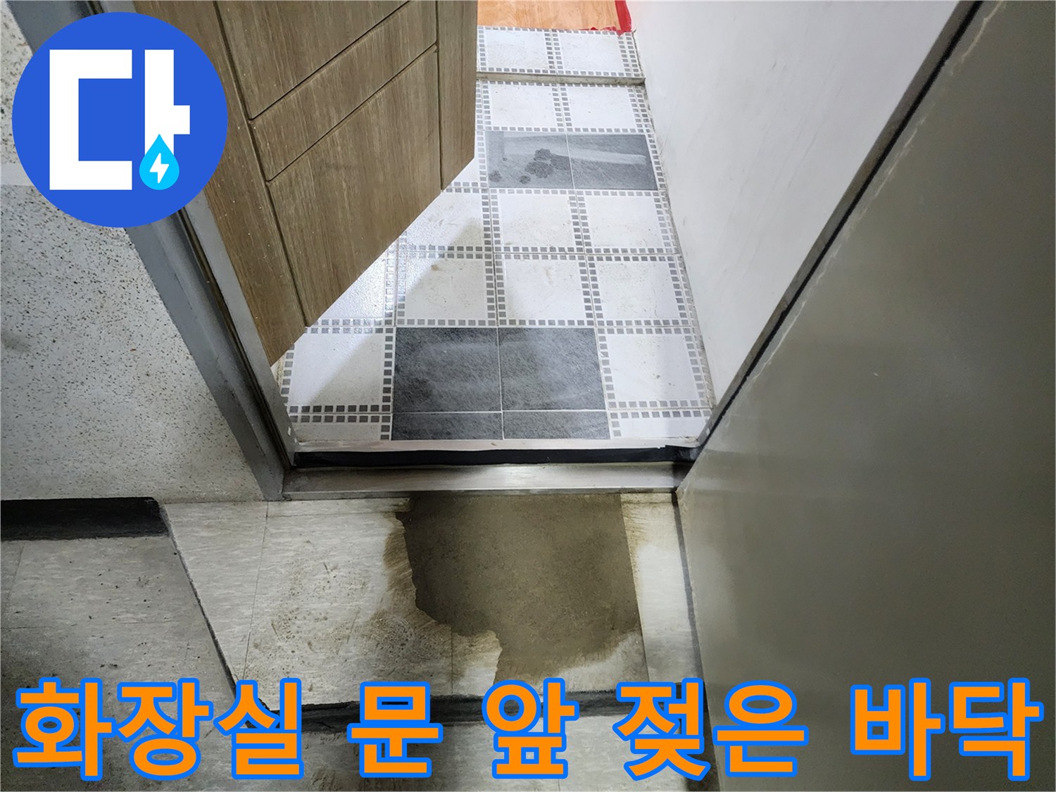 화장실 입구 타일 주변의 짙은 습기 흔적
