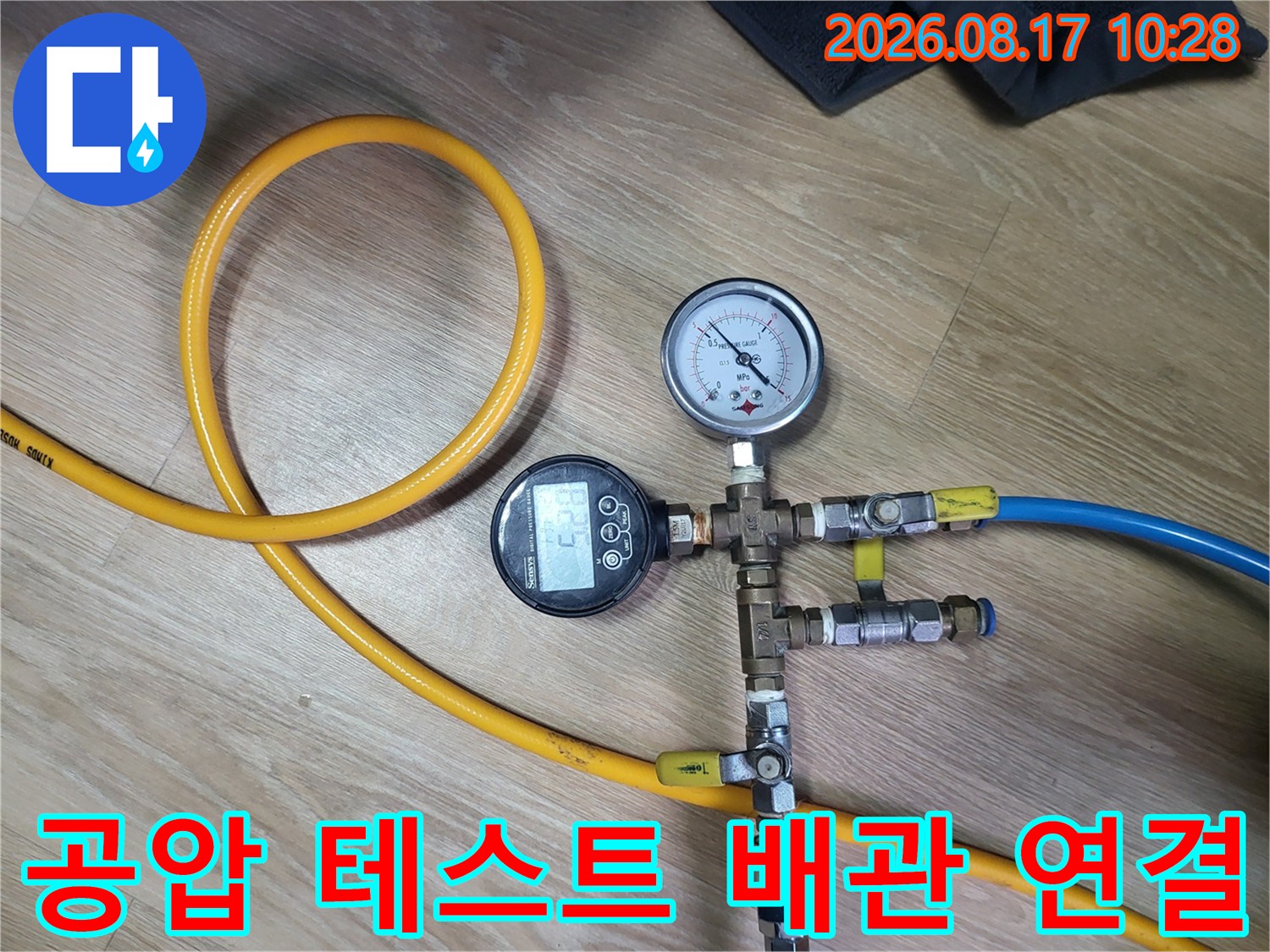 노란색 호스와 파란색 호스가 연결된 배관 압력 측정 장치