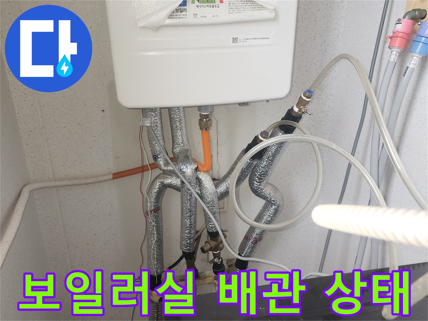 보일러 아래 연결된 은색 보온재 배관 모습