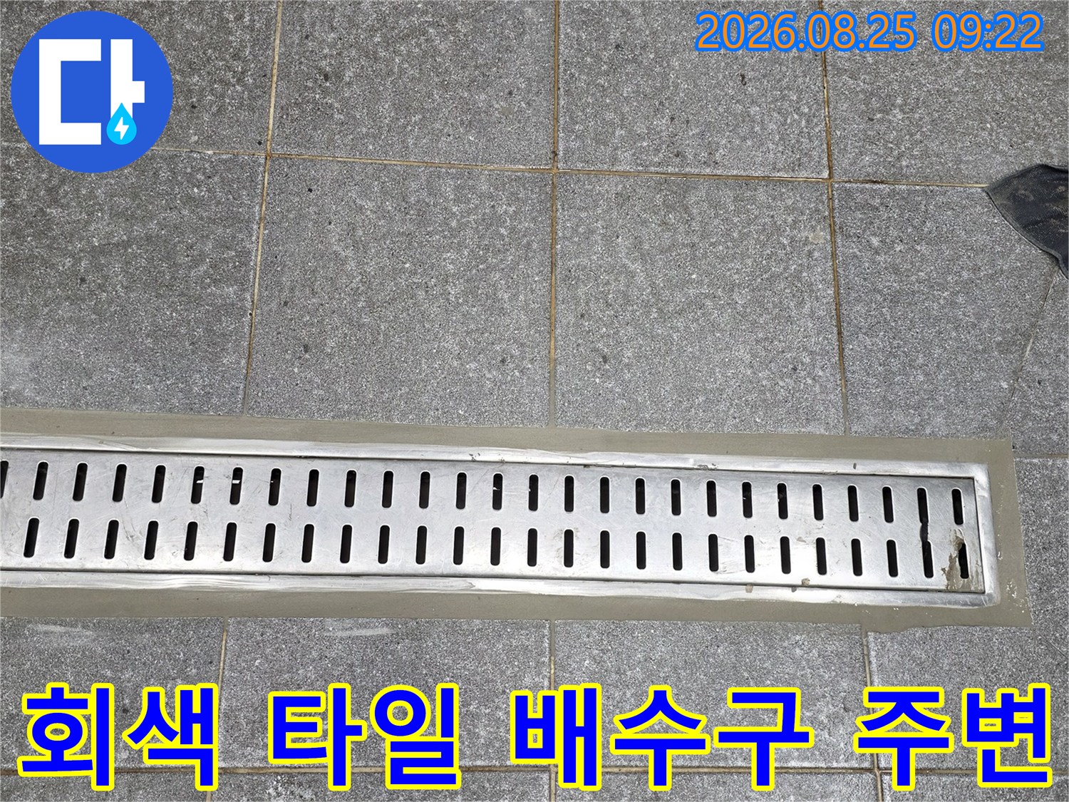 회색 바닥 타일과 스테인리스 배수 시설