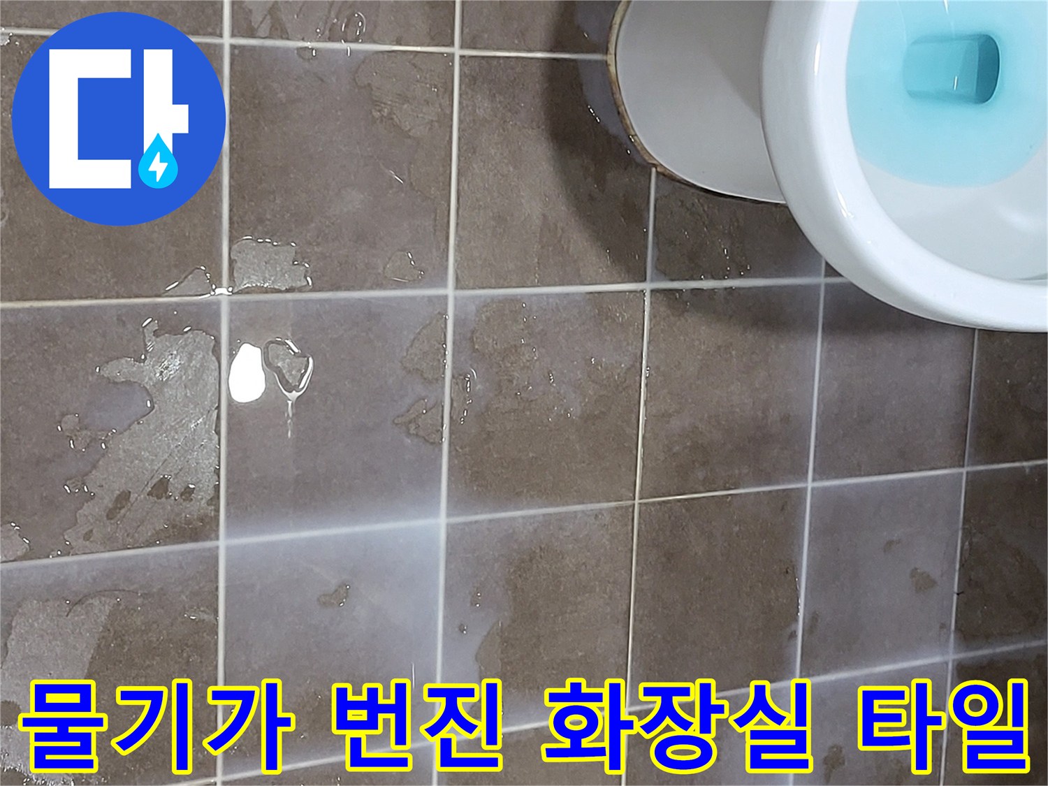 변기 옆쪽으로 물이 고여 있는 바닥 사진