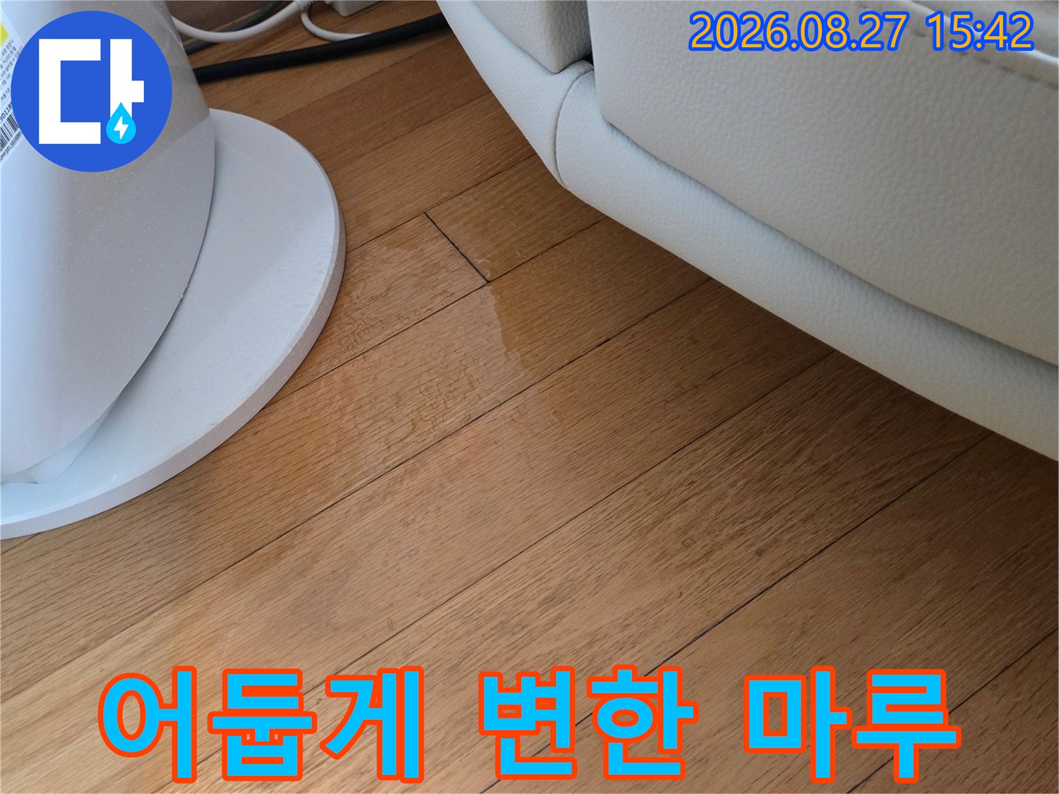 소파 아래 거실 바닥의 물에 의한 마루 변색 부위