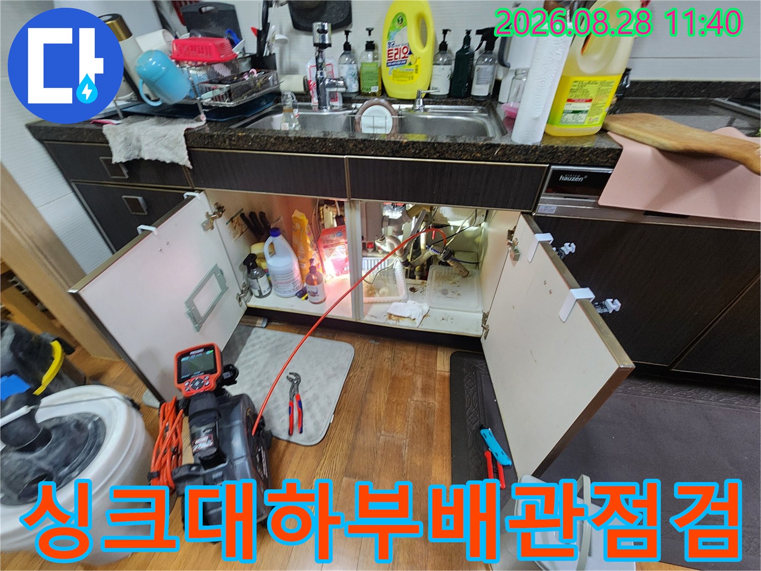 싱크대 아래 배관 연결 부위와 점검용 장비 모습