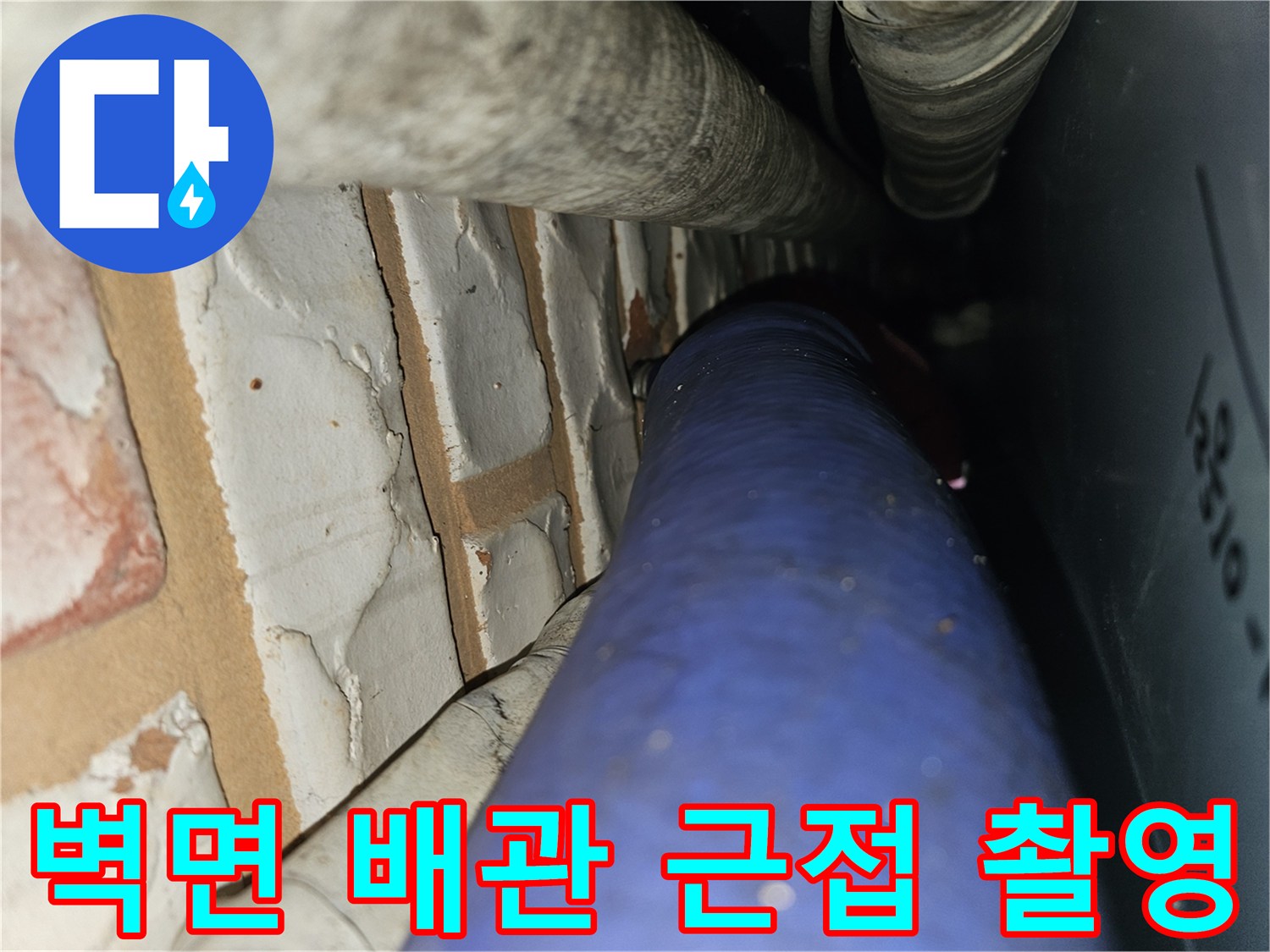 벽돌 벽체와 파란색 배관의 연결 부위 근접샷