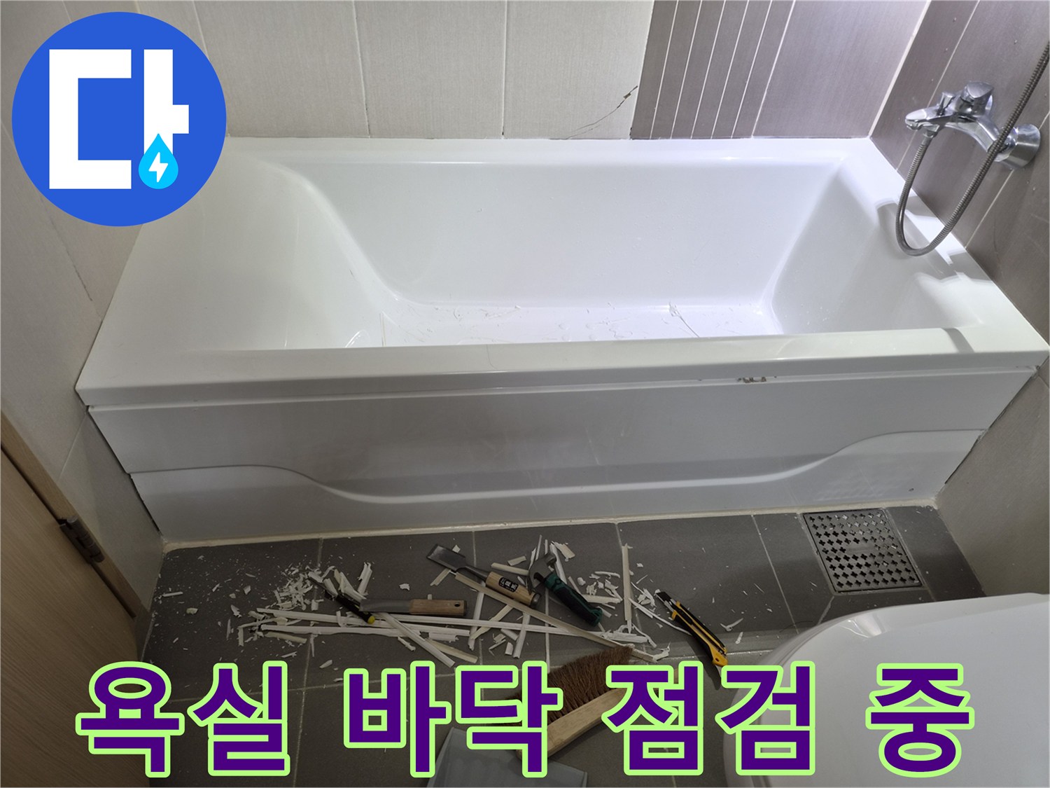 하얀색 욕조와 바닥 배수구가 있는 화장실 내부 사진