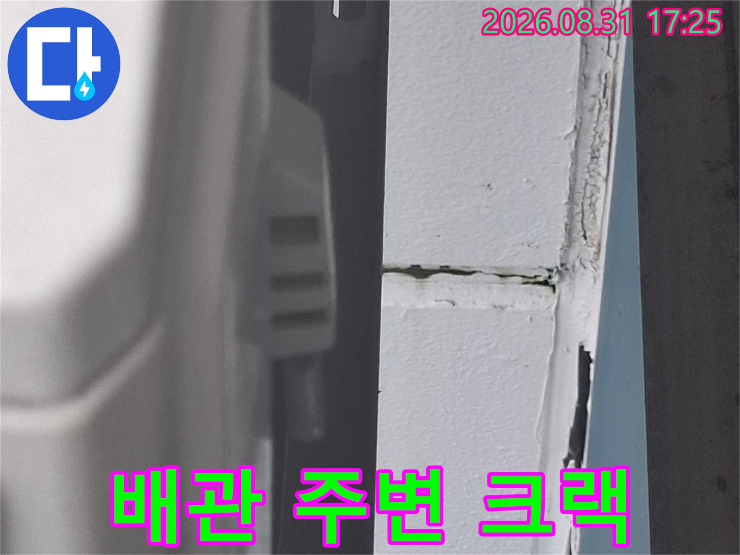 에어컨 배관 관통 부위의 균열된 외벽 상태를 보여줍니다.