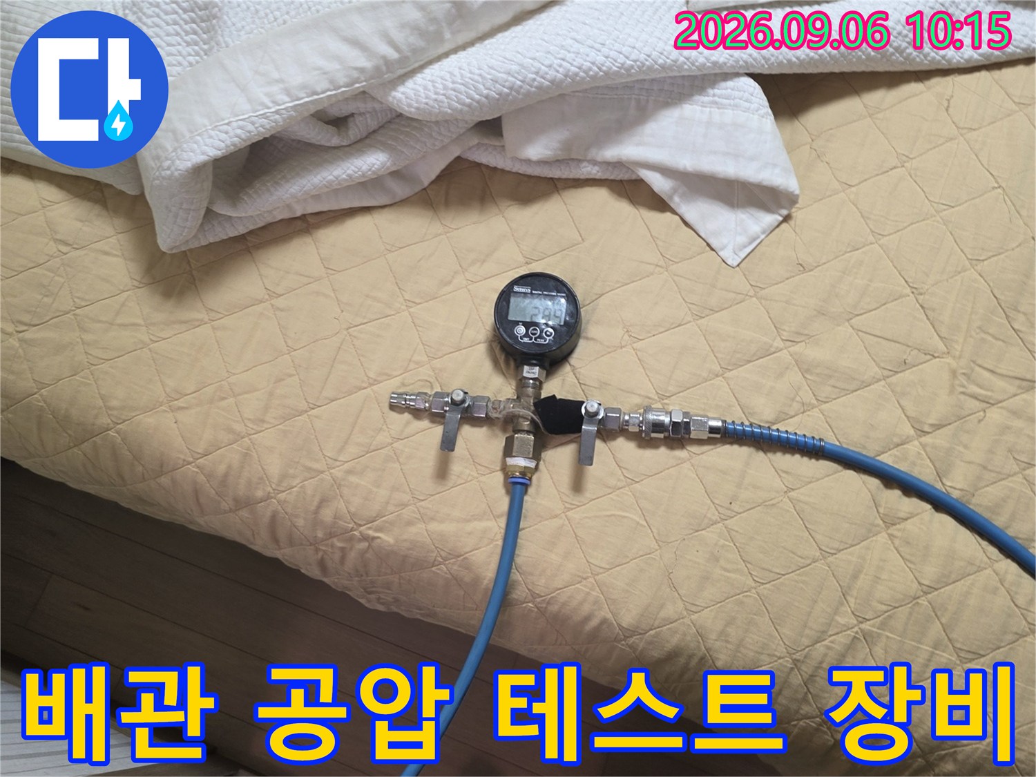 파란색 호스와 압력계가 연결된 배관 점검 장치