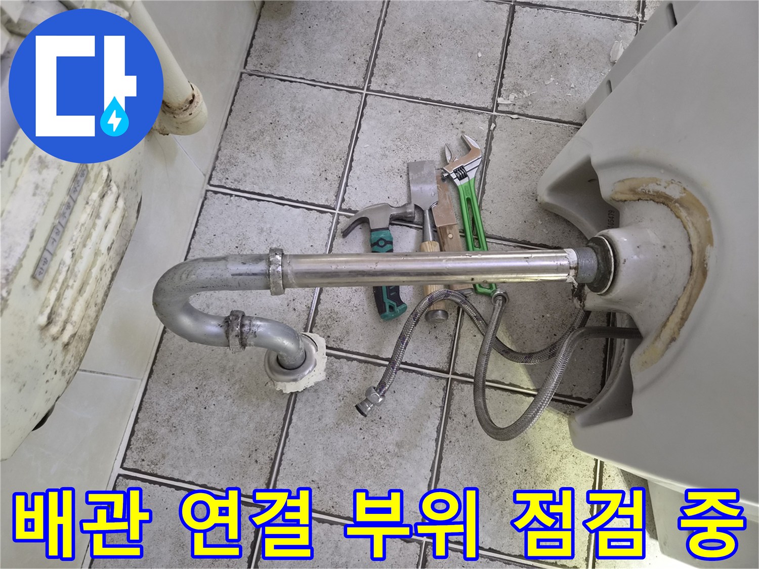 탈거된 위생기구 아래 배관과 공구가 놓인 현장 모습