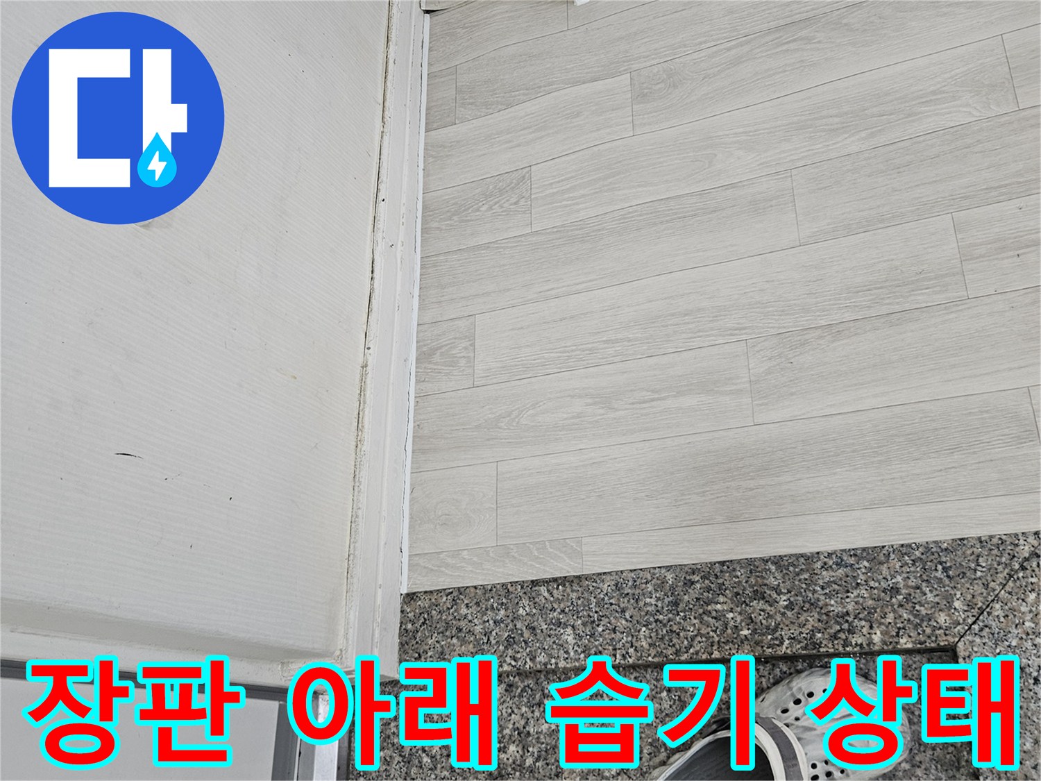 거실 바닥 마감재 하단의 습윤한 상태와 변색 부위