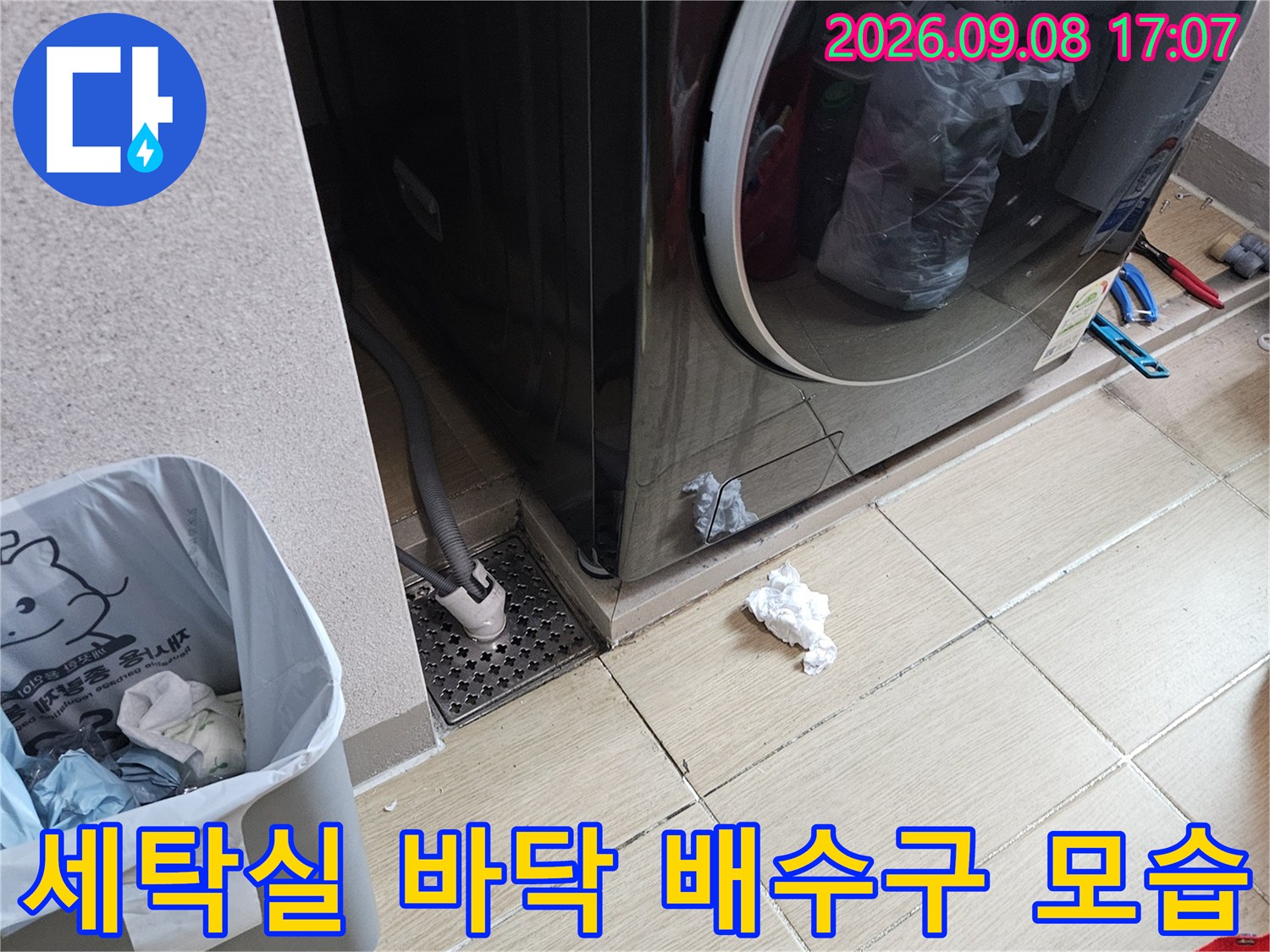 드럼세탁기 옆 세탁실 바닥의 배수구와 타일 구조물