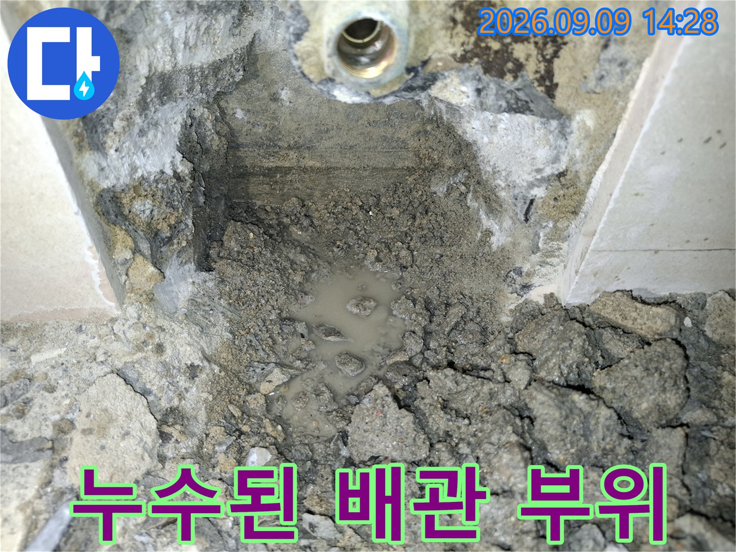 금속 연결 부속 주변으로 물이 새어 나온 굴착 현장입니다.